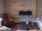 Stone fireplace wall with floating shelves & Horizontal gas fireplace.